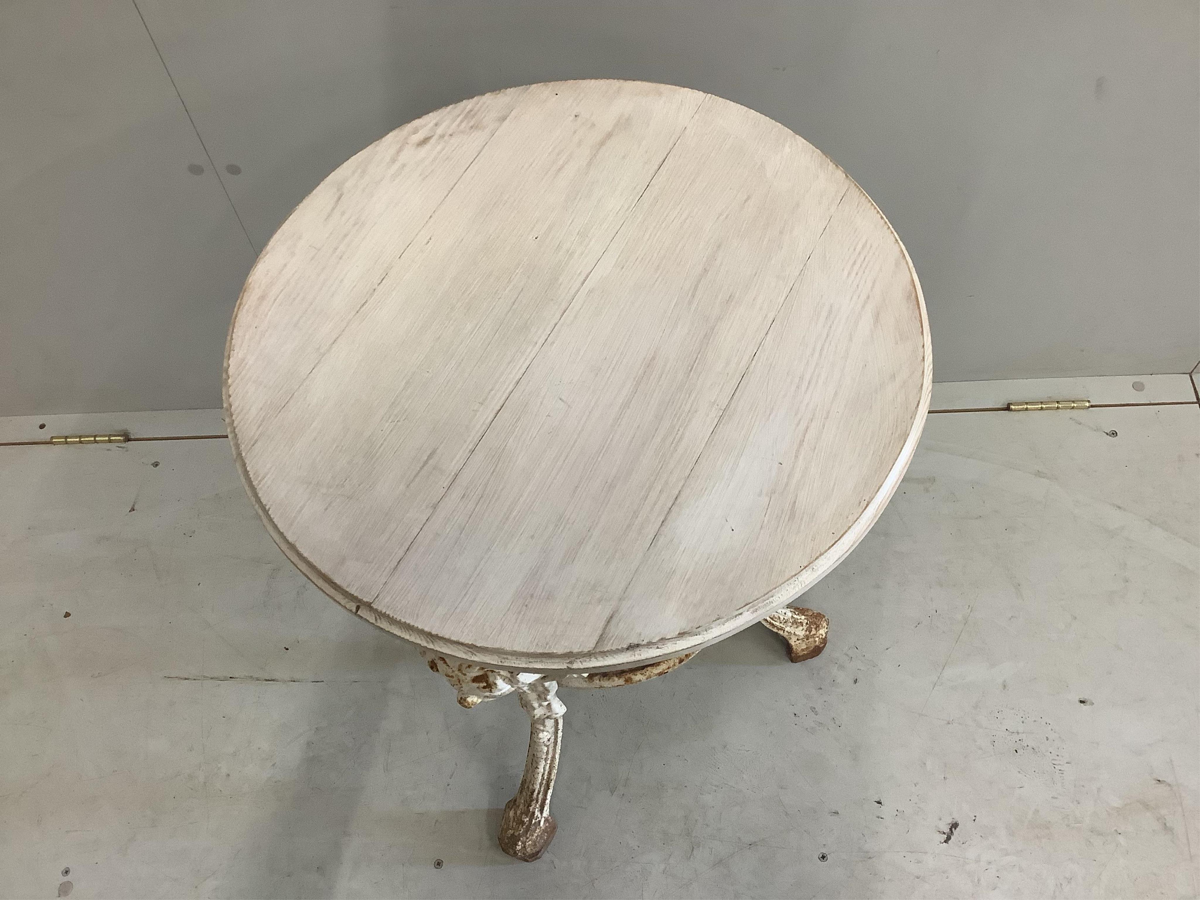 A white painted cast iron circular pub table, with later white stained wooden top, diameter 50cm, height 70cm. Condition - some oxidisation, otherwise good